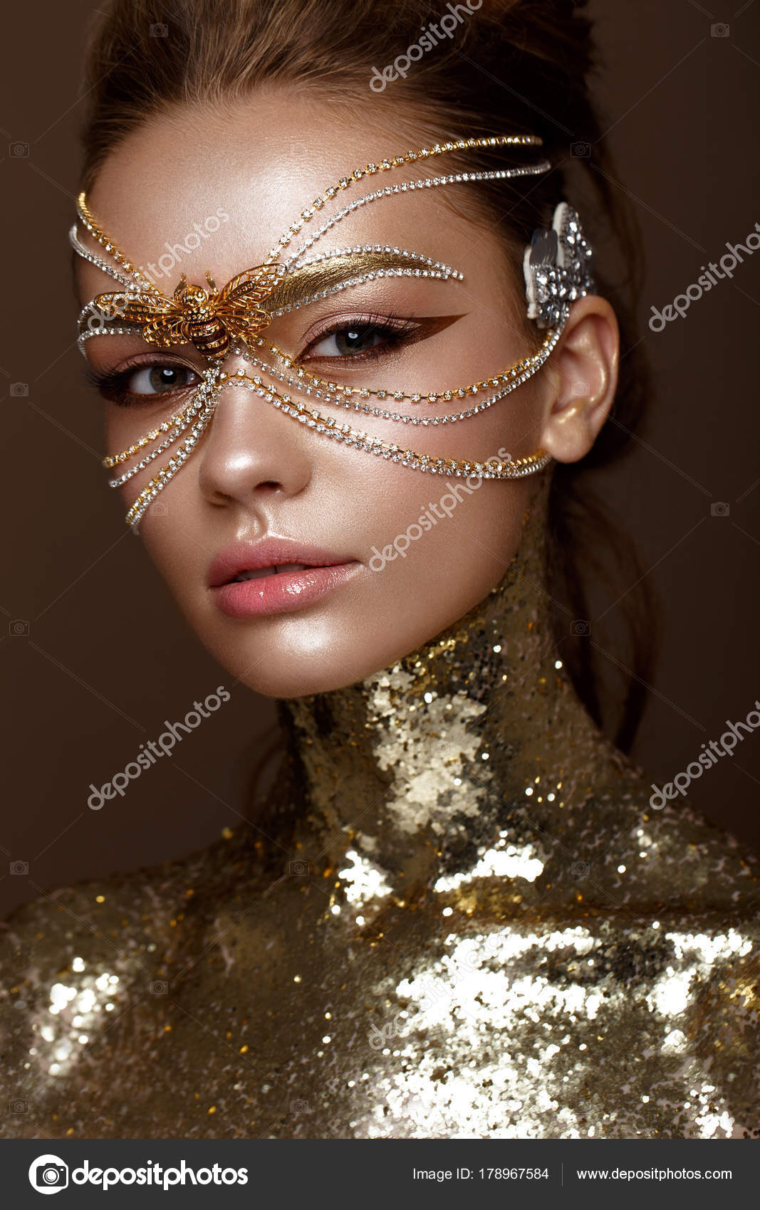 Menina bonita em máscara dourada e maquiagem noite brilhante. Cara